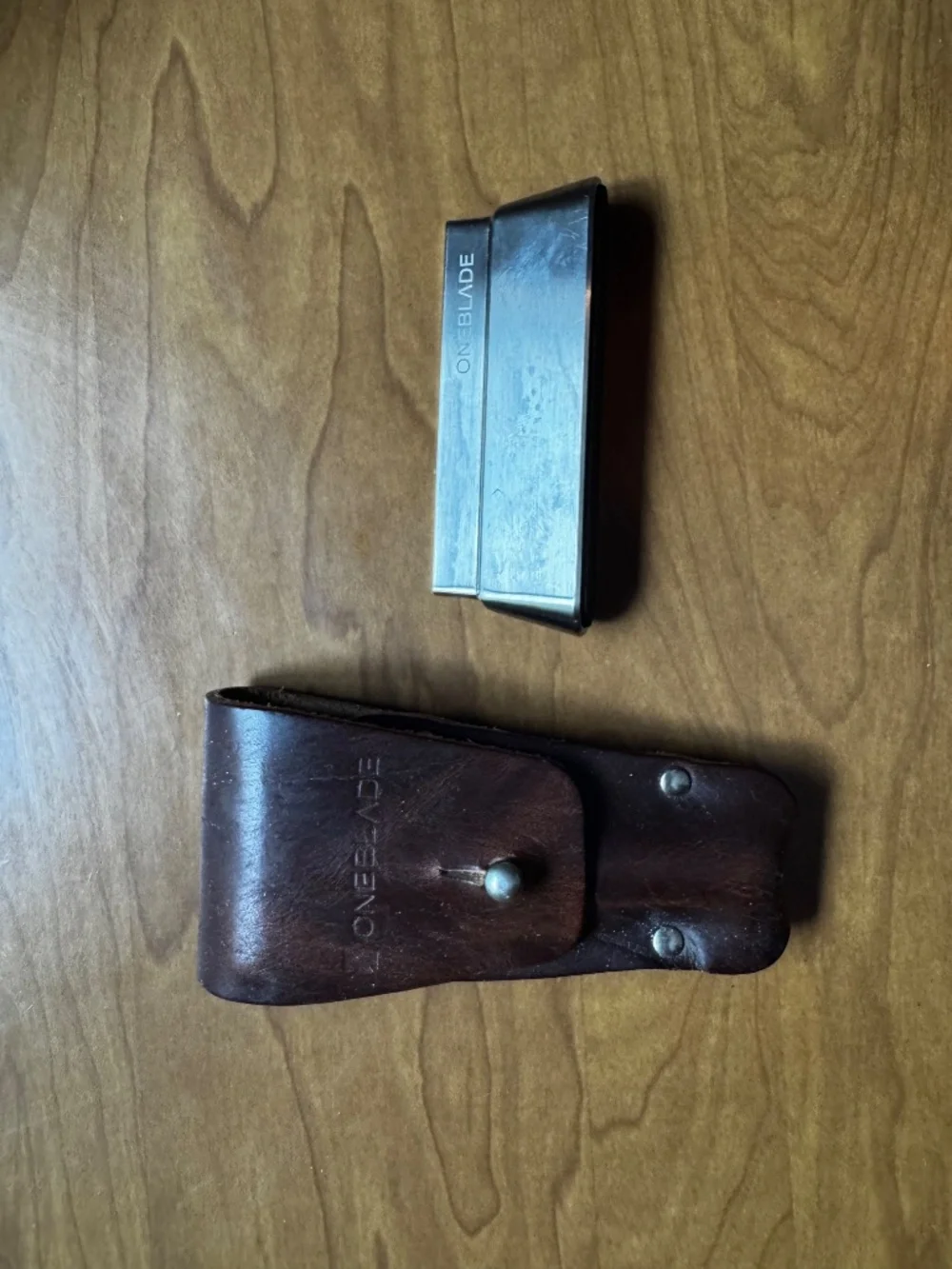 OneBlade razor with leather case, metal stand, and blades